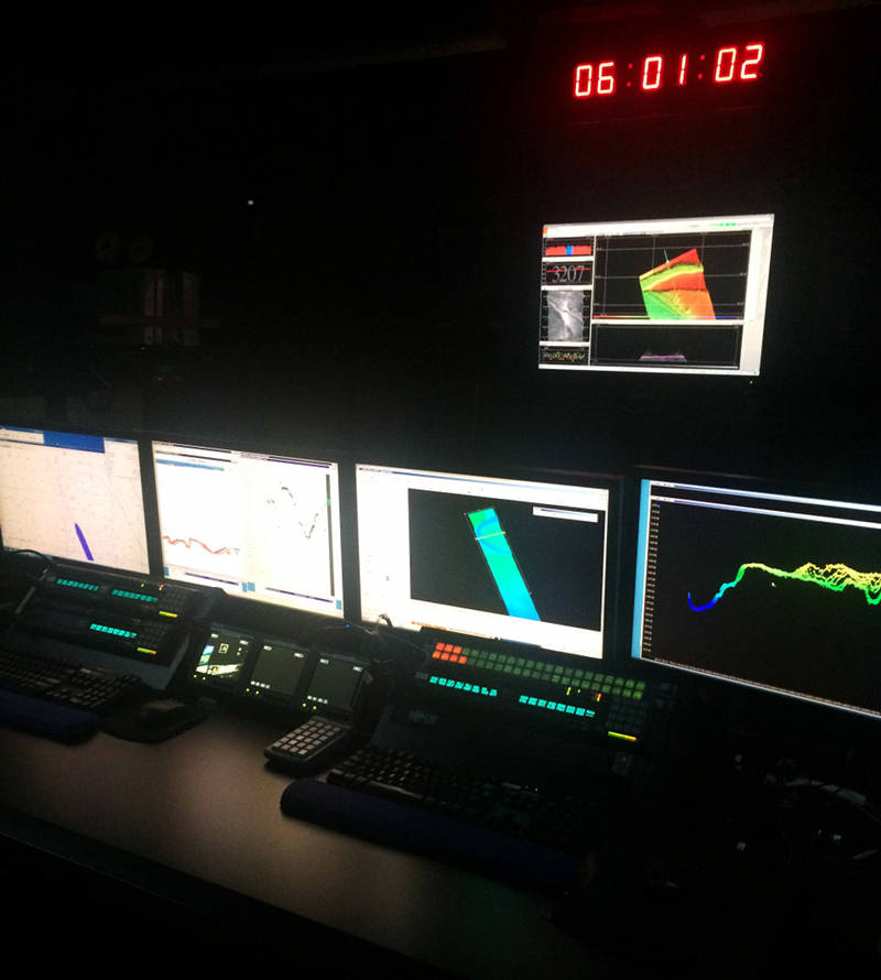 On the screens of the control room from left to right: digital nautical charts that show our relative position; data acquisition screens from the EK60 and sub-bottom profiler sonars; multibeam data processing in CARIS. At the top of the image is the UTC time and the data acquisition screen from the EM302 multibeam sonar. You can also see the RTS intercom units that we use to communicate throughout the ship and with shore underneath the computer screens.