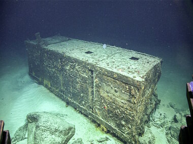 At 785 meters depth, ROV Deep Discoverer encountered a WWII-period causeway called a “rhino barge”. Rhino barges were large floating platforms comprised of joined together steel pontoons that could transport vehicles and supplies to beaches. This is one pontoon.